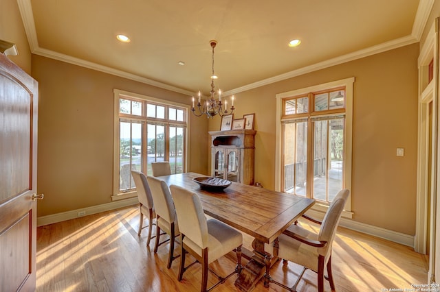 dining space with a chandelier, light hardwood / wood-style floors, and ornamental molding