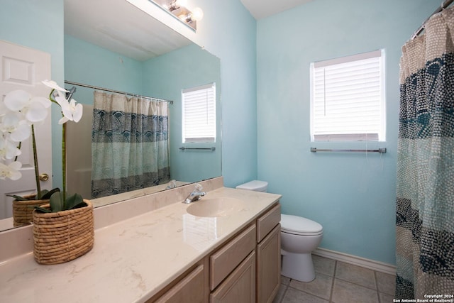 bathroom with tile patterned flooring, vanity, a healthy amount of sunlight, and toilet