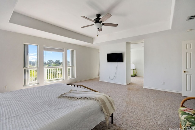 bedroom featuring a tray ceiling, ceiling fan, and light colored carpet