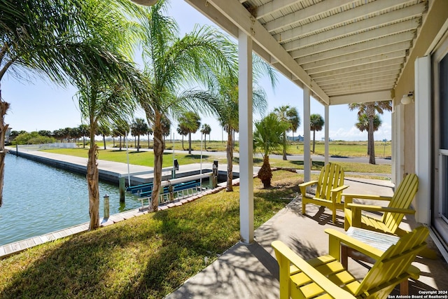 view of dock with a lawn and a water view