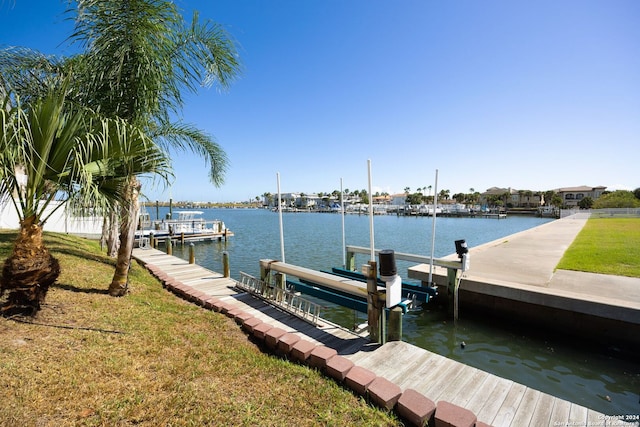 view of dock featuring a lawn and a water view