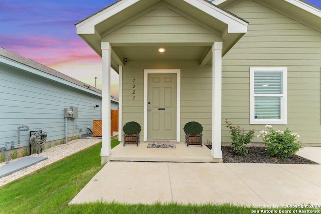 exterior entry at dusk featuring covered porch