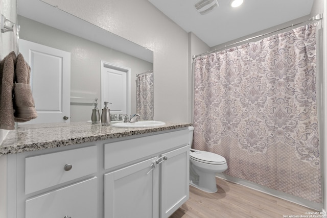 full bathroom with shower / bath combination with curtain, vanity, hardwood / wood-style flooring, and toilet