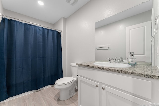 bathroom with hardwood / wood-style floors, vanity, and toilet