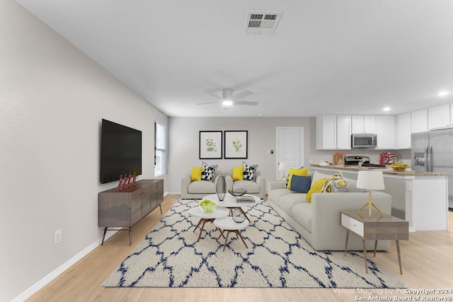 living room featuring ceiling fan and light wood-type flooring