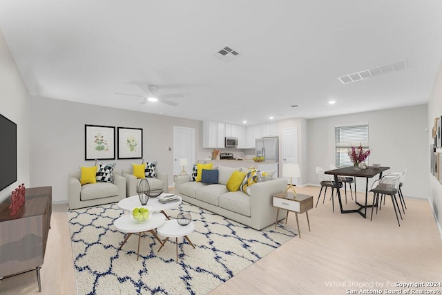 living room featuring light hardwood / wood-style floors and ceiling fan