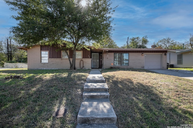 single story home featuring a garage and a front lawn