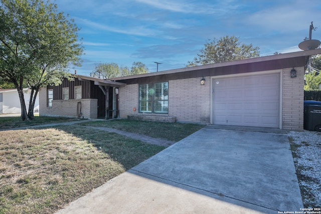 ranch-style house featuring a garage and a front yard