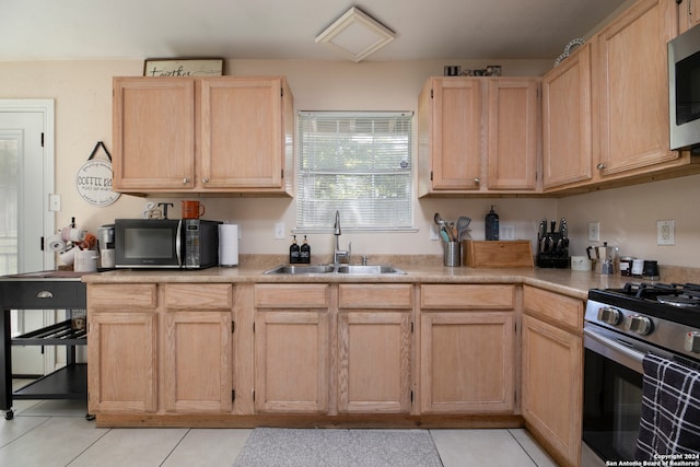 kitchen featuring sink, light tile patterned floors, stainless steel appliances, and light brown cabinetry