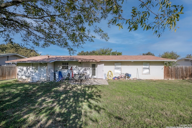 back of house featuring a patio area and a lawn