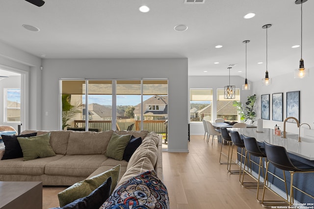 living room featuring sink and light hardwood / wood-style flooring