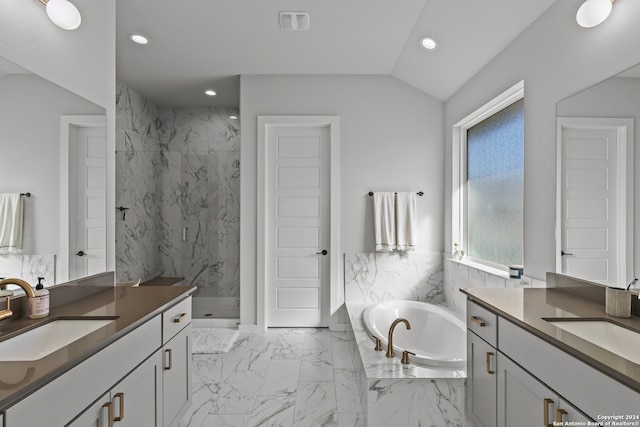 bathroom featuring vanity, vaulted ceiling, and shower with separate bathtub