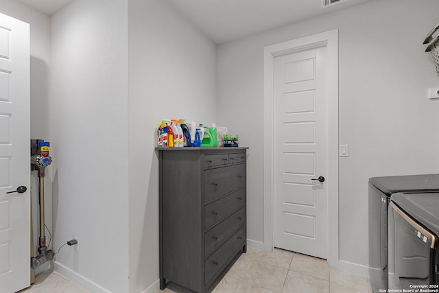 1521 Escarpment, New Braunfels, TX 78132 - laundry room featuring washing machine and clothes dryer, baseboards, and light tile patterned floors