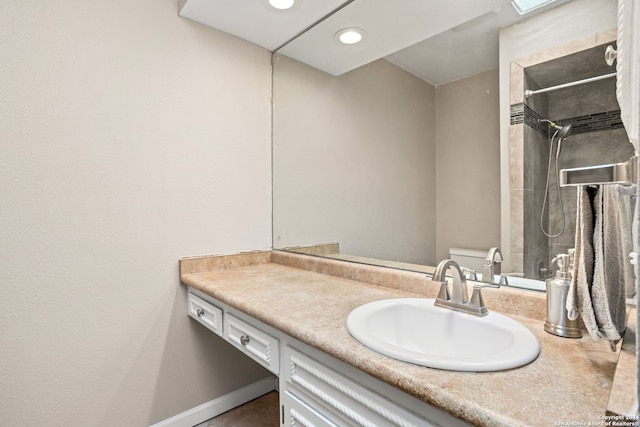 bathroom featuring vanity, toilet, and a tile shower