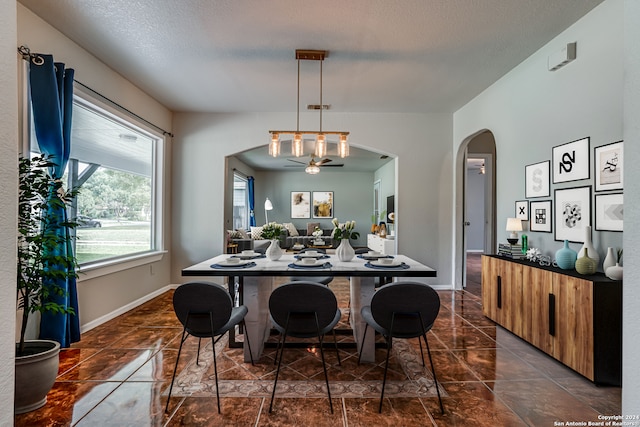 dining space with a textured ceiling and ceiling fan