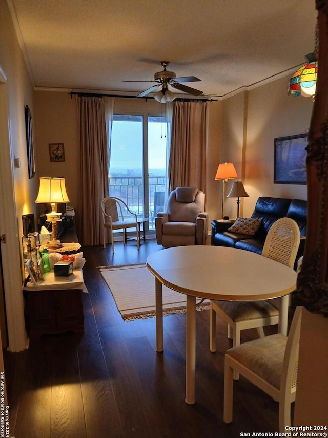 living room with ceiling fan, crown molding, dark wood-type flooring, and a wall of windows