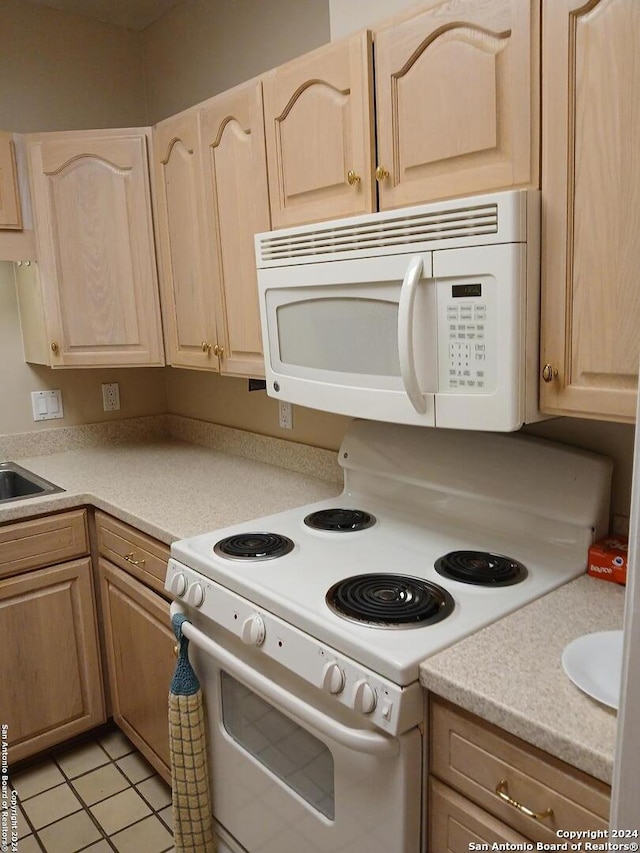 kitchen featuring light brown cabinetry, white appliances, and light tile patterned floors