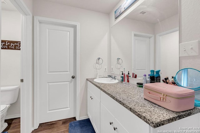 bathroom featuring vanity, toilet, and wood-type flooring