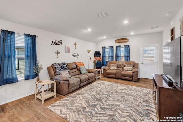 living room with vaulted ceiling and light hardwood / wood-style flooring