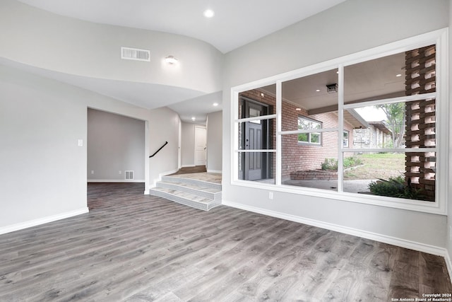 unfurnished room featuring hardwood / wood-style flooring and lofted ceiling