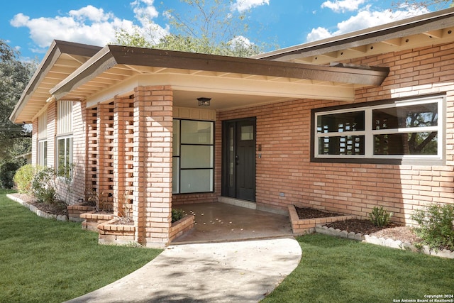 entrance to property with a lawn