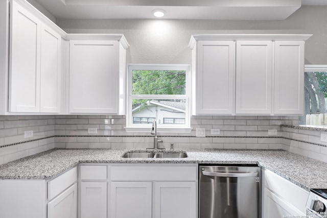 kitchen with white cabinetry, stainless steel dishwasher, tasteful backsplash, and sink