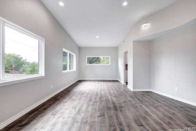 spare room featuring dark hardwood / wood-style flooring and lofted ceiling