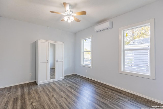 unfurnished bedroom featuring a wall mounted air conditioner, a closet, ceiling fan, and dark wood-type flooring