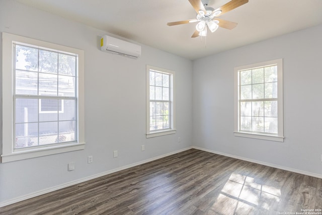 unfurnished room with an AC wall unit, a wealth of natural light, ceiling fan, and dark wood-type flooring