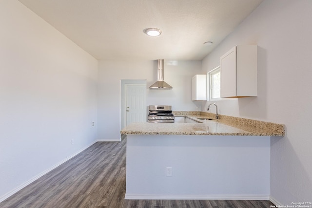 kitchen with white cabinetry, sink, wall chimney exhaust hood, stainless steel range with gas cooktop, and dark hardwood / wood-style flooring