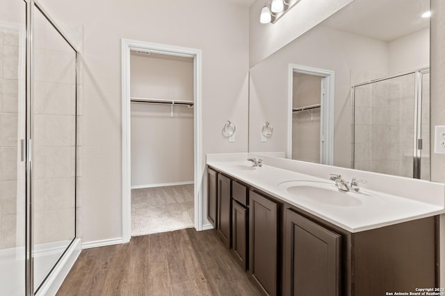 bathroom featuring hardwood / wood-style floors, vanity, and an enclosed shower