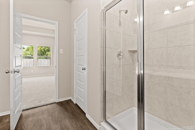 bathroom with wood-type flooring and an enclosed shower