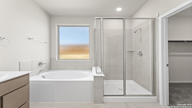 bathroom with tile patterned floors, vanity, and shower with separate bathtub