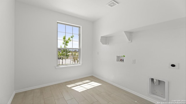 laundry area with electric dryer hookup, washer hookup, and light hardwood / wood-style floors