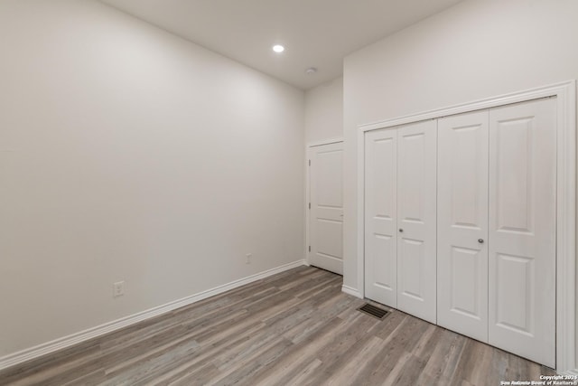 unfurnished bedroom featuring light wood-type flooring and a closet