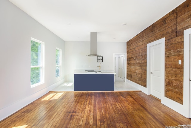 unfurnished living room with wood-type flooring and wooden walls