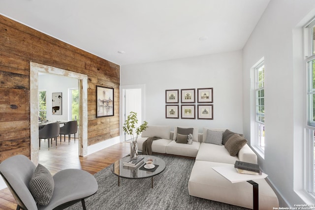 living room featuring plenty of natural light, wood walls, and light wood-type flooring