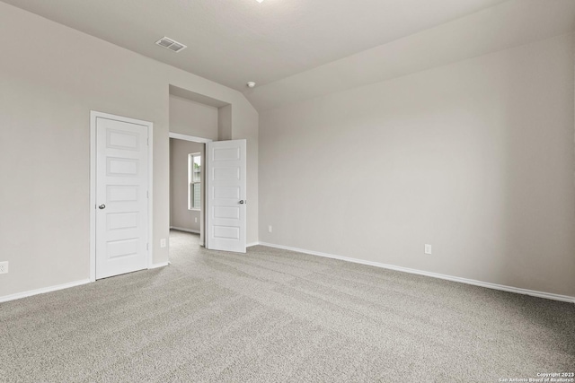 empty room featuring carpet flooring and lofted ceiling