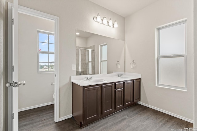 bathroom with hardwood / wood-style floors, vanity, toilet, and a shower with door