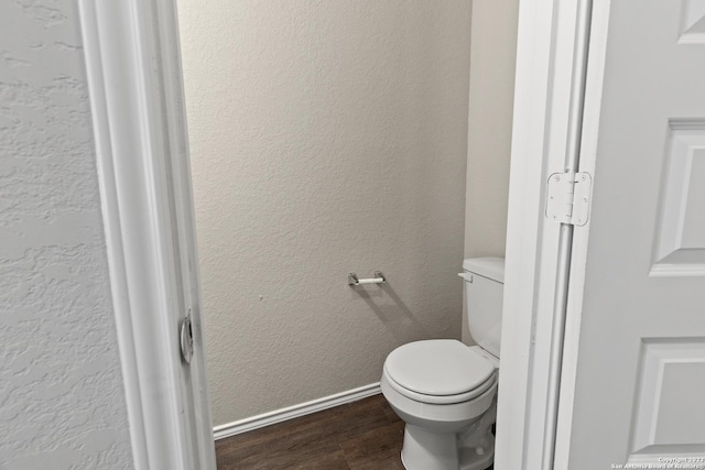 bathroom with hardwood / wood-style flooring and toilet