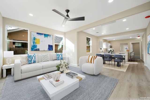 living room with light wood-type flooring and ceiling fan