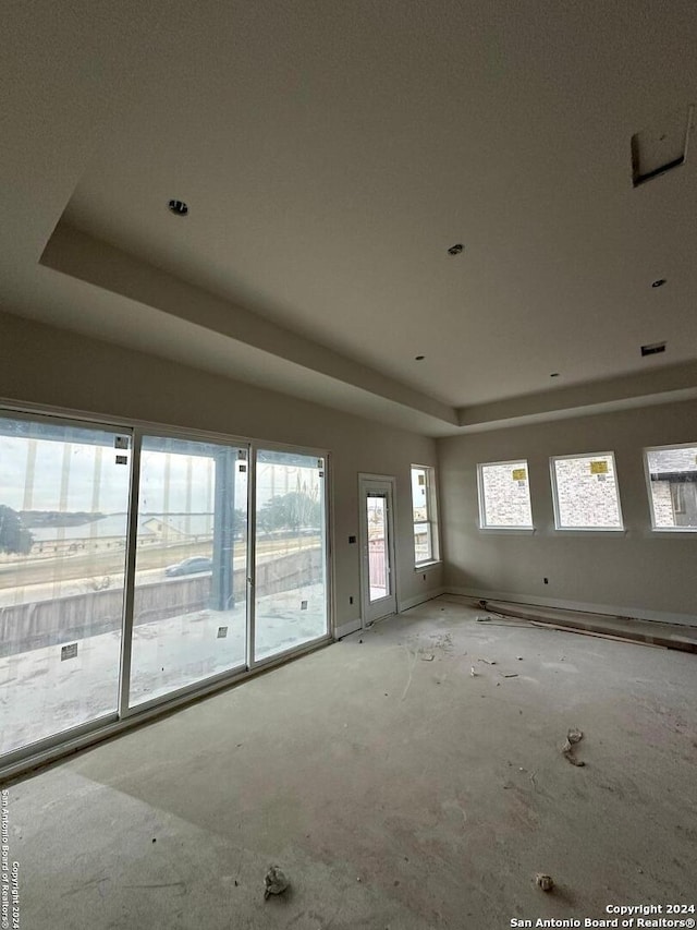 unfurnished living room with a raised ceiling