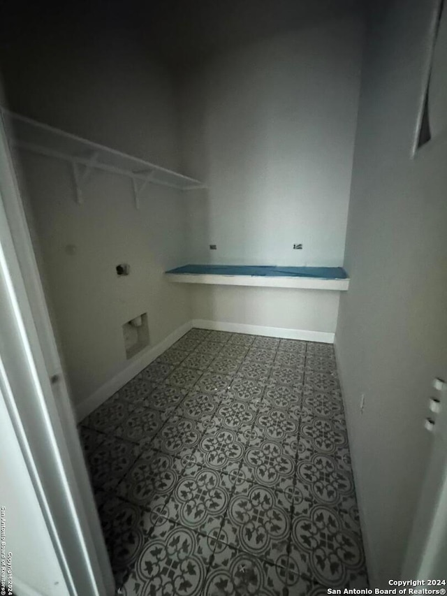 washroom with hookup for an electric dryer and tile patterned flooring