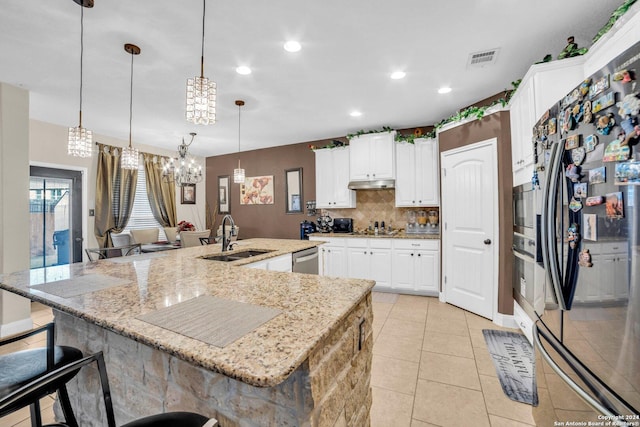 kitchen with stainless steel appliances, sink, white cabinets, hanging light fixtures, and a large island