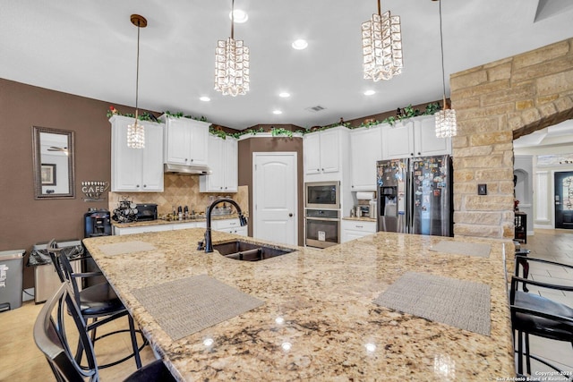 kitchen with decorative backsplash, pendant lighting, stainless steel appliances, and sink