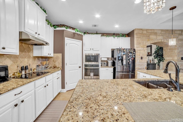 kitchen with light stone countertops, stainless steel appliances, sink, pendant lighting, and white cabinetry