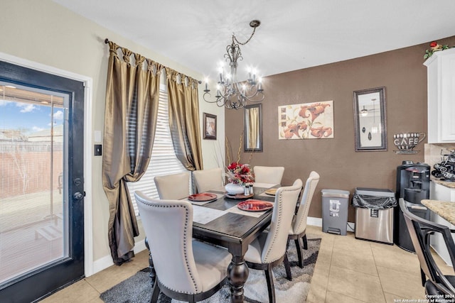 dining space featuring light tile patterned flooring and an inviting chandelier