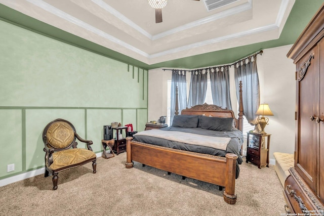 carpeted bedroom featuring a raised ceiling, ceiling fan, and ornamental molding