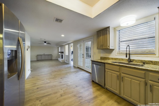 kitchen featuring ceiling fan, sink, french doors, stainless steel appliances, and light hardwood / wood-style floors