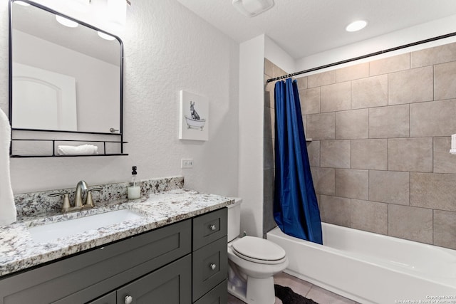 full bathroom featuring shower / tub combo, tile patterned floors, vanity, a textured ceiling, and toilet